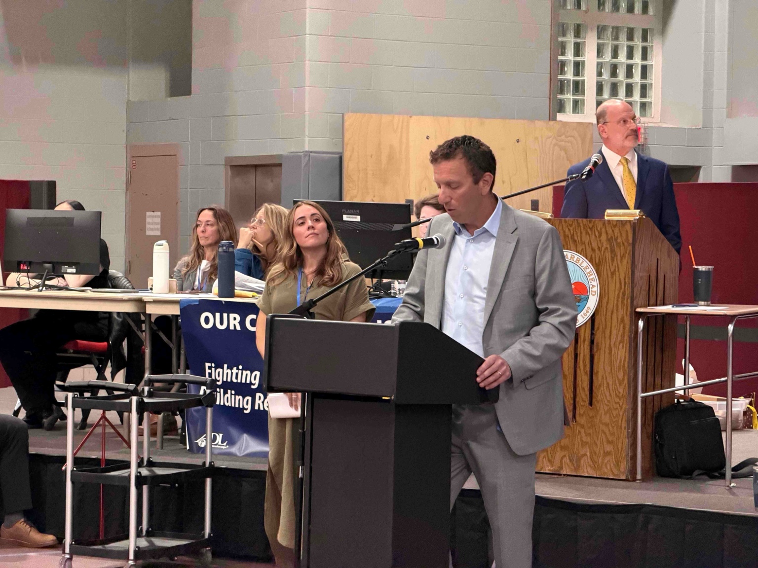 Select Board Chair Dan Fox at the lectern presenting Article 29, with Town Moderator Jack Attridge at the moderator's podium behind him.