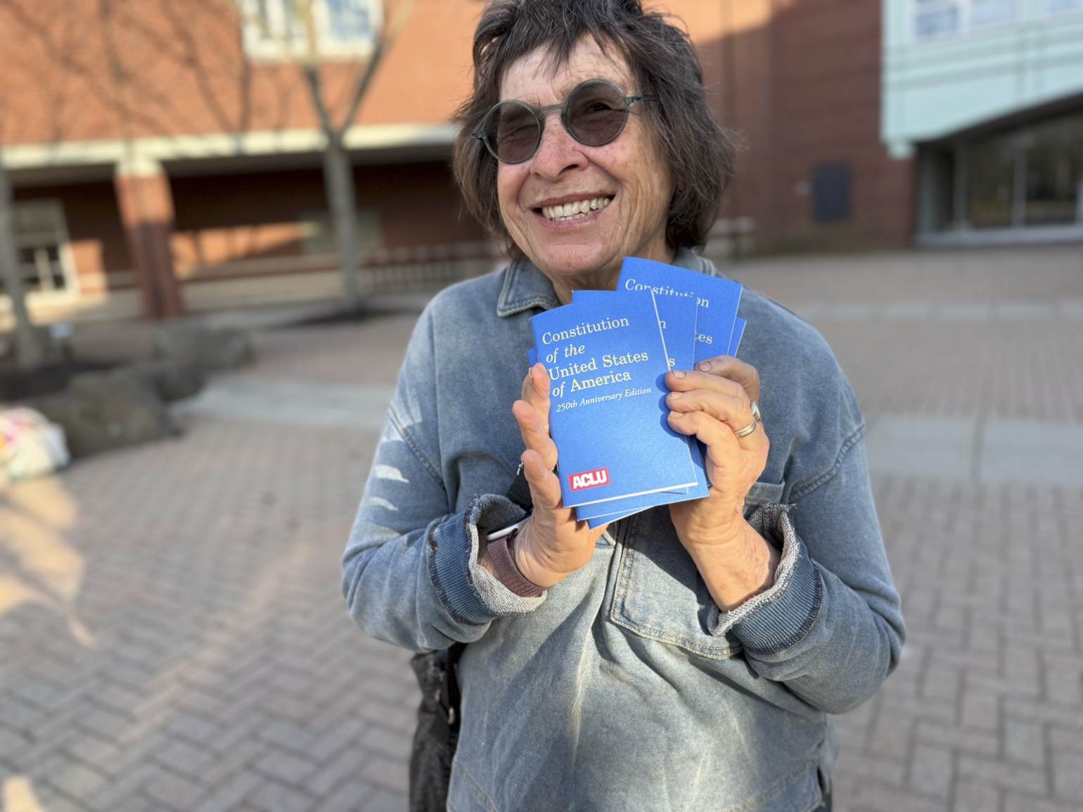 Lynn Nadeau, a citizen petitioner behind Article 40, holds copies of the U.S. Constitution outside Marblehead High School ahead of the 2026 Annual Town Meeting.