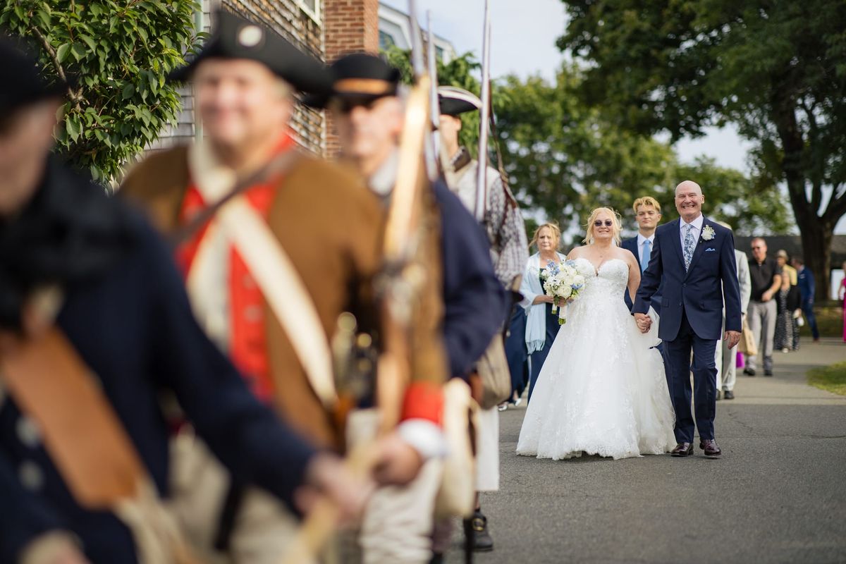 Michelle Brown and James Maroney walk behind Glover's Marblehead Regiment after their Crocker Park wedding